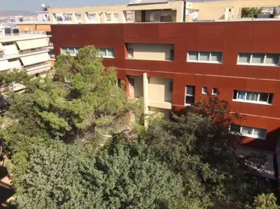an apartment building with trees in front of it at Vasos apartment in Athens