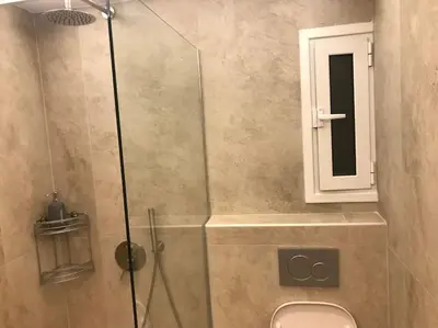 a bathroom with a shower with a toilet and a mirror at Vasos apartment in Athens