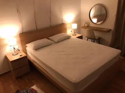 a bedroom with a bed with two lamps and a mirror at Vasos apartment in Athens