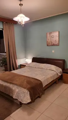 a bedroom with a large bed in a room at M&M Airport stop Garden Apartment in Spáta