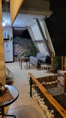 a patio with benches and tables in a building at M&M Airport stop Garden Apartment in Spáta