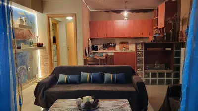 a living room with a couch and a table at M&M Airport stop Garden Apartment in Spáta