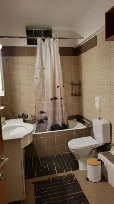 a bathroom with a toilet and a sink and a shower at M&M Airport stop Garden Apartment in Spáta