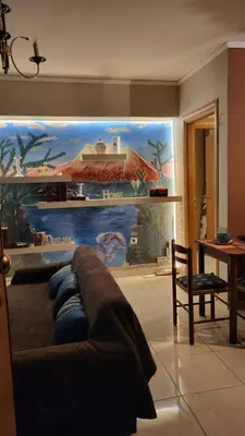 a living room with a large painting on the wall at M&M Airport stop Garden Apartment in Spáta