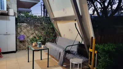 a living area with a couch and a table at M&M Airport stop Garden Apartment in Spáta