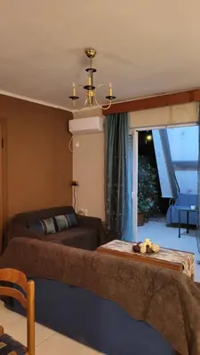 a living room with a bed and a couch at M&M Airport stop Garden Apartment in Spáta