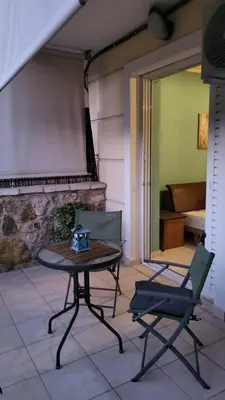 a table and a chair in a room with a fireplace at M&M Airport stop Garden Apartment in Spáta