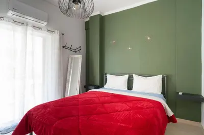 a bedroom with a red bed with a green wall at Majestic 2 Glyfada in Athens