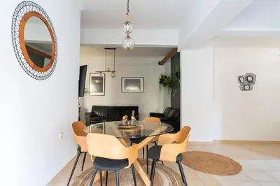 a dining room with a glass table and chairs at Majestic 2 Glyfada in Athens