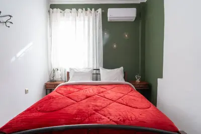 a bedroom with a red bed with a window at Majestic 2 Glyfada in Athens