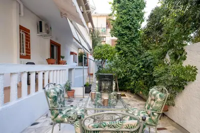 a patio with a glass table and chairs on a balcony at Majestic 2 Glyfada in Athens