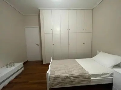 a white bedroom with a bed and white cabinets at DM Apartment 1 in Athens
