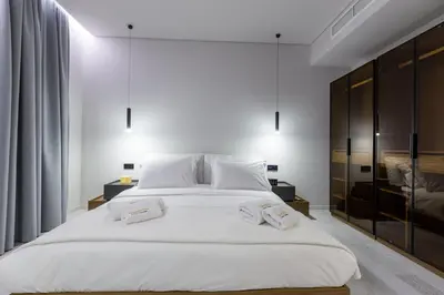 a bedroom with a large white bed with two towels on it at Zambelis Luxury Home Spa in Athens