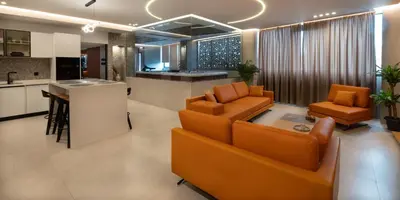 a living room with orange chairs and a kitchen at Zambelis Luxury Home Spa in Athens