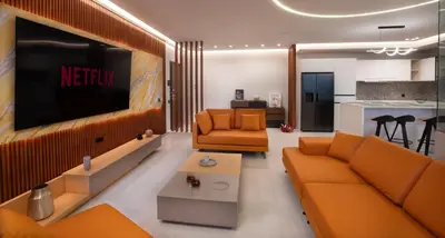 a living room with orange furniture and a flat screen tv at Zambelis Luxury Home Spa in Athens