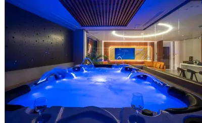 a hot tub in a hotel room with wine glasses at Zambelis Luxury Home Spa in Athens