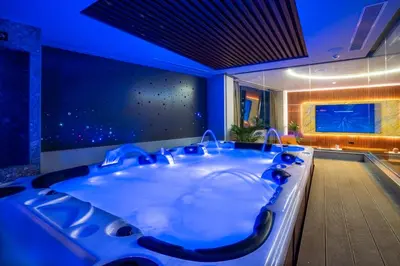 a jacuzzi tub in a bathroom with blue lighting at Zambelis Luxury Home Spa in Athens
