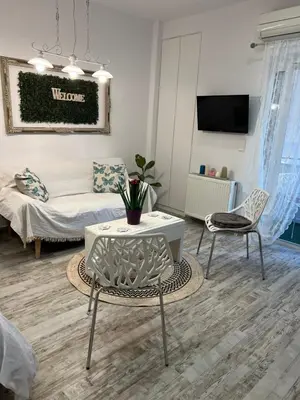 a living room with a couch and a table at Selenity studio(close to two metro stations) in Piraeus