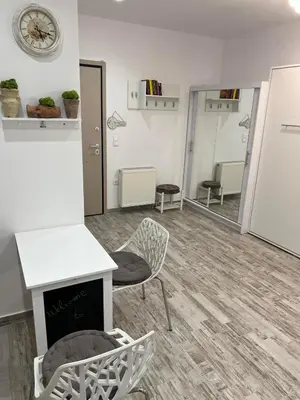 a room with a fireplace and a chair and a clock at Selenity studio(close to two metro stations) in Piraeus
