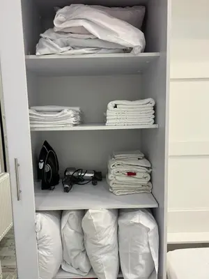 a closet filled with white linen and towels at Selenity studio(close to two metro stations) in Piraeus