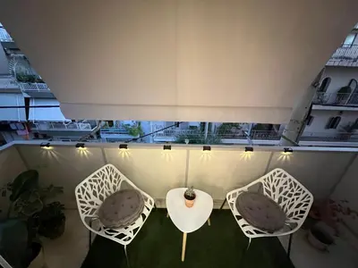 three chairs and a table on a balcony at Selenity studio(close to two metro stations) in Piraeus