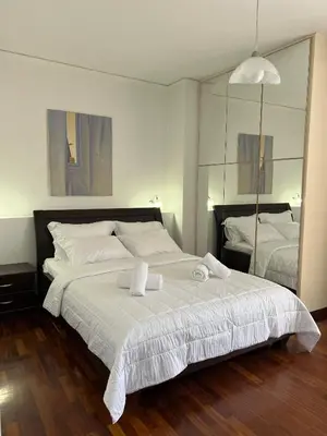 a bedroom with a large white bed with towels on it at Machi's Apartment in Markopoulo