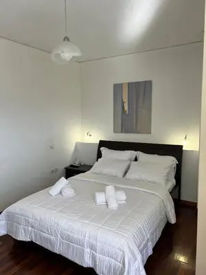 a bedroom with a large white bed with towels on it at Machi's Apartment in Markopoulo