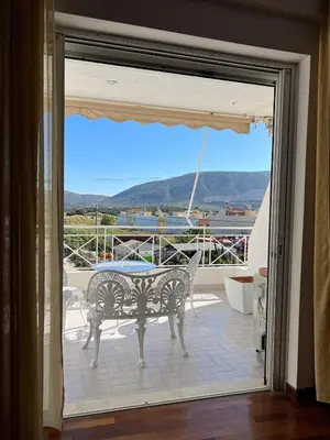 a glass door leading to a patio with a table at Machi's Apartment in Markopoulo