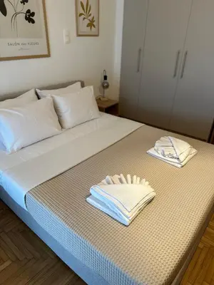 a bed with two towels on top of it at Cozy Faliro home in Piraeus