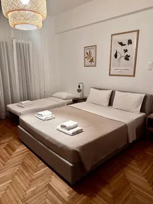 a bedroom with a bed with two towels on it at Cozy Faliro home in Piraeus
