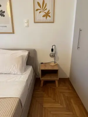 a small bedroom with a bed and a night stand at Cozy Faliro home in Piraeus