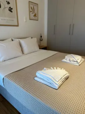 a bed with two towels on top of it at Cozy Faliro home in Piraeus