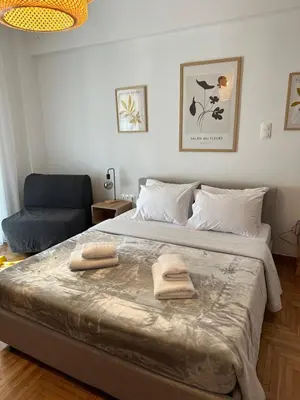 a bedroom with a large bed with two towels on it at Cozy Faliro home in Piraeus