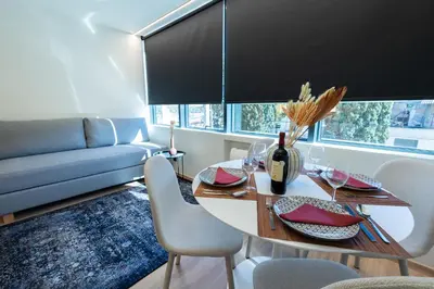 a living room with a table and chairs and a couch at Athens Airport Living spaces in Spáta