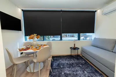 a living room with a table and a couch at Athens Airport Living spaces in Spáta