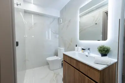 a bathroom with a sink and a toilet and a mirror at Athens Airport Living spaces in Spáta