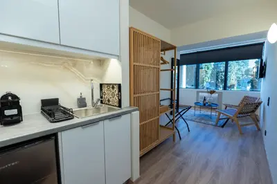 a kitchen with a sink and a living room at Athens Airport Living spaces in Spáta