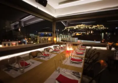 a long table in a restaurant with a view of the city at 360 Degrees in Athens