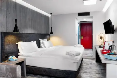 a bedroom with a large white bed and a red door at 360 Degrees in Athens