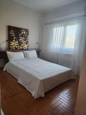 a bedroom with a large white bed with a window at Peaceful oasis in Athens
