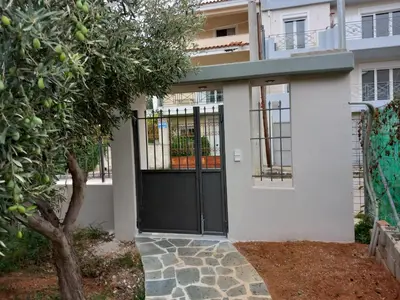 a black front door of a white house at pavlosloft in Leondárion