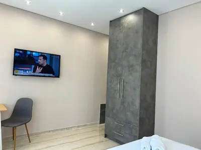 a room with a tv on the wall and a bed at PORT TWINS SUITES No1 in Piraeus