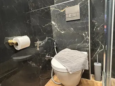 a black marble bathroom with a toilet and a shower at PORT TWINS SUITES No1 in Piraeus