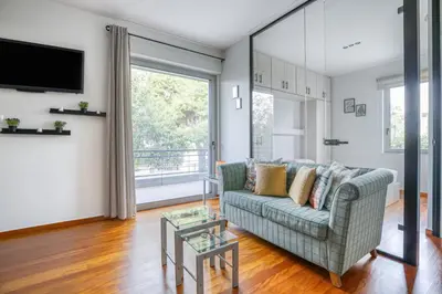 a living room with a couch and a tv at Athena's South Apartment in Athens