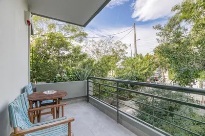 a balcony with a table and chairs on a balcony at Athena's South Apartment in Athens