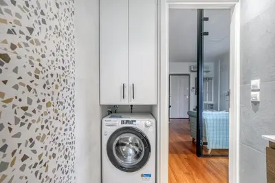 a washer and dryer in a room with a wall at Athena's South Apartment in Athens