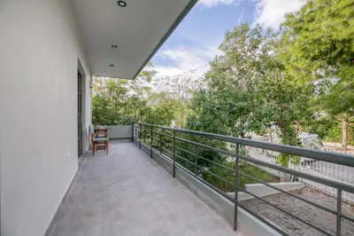a balcony with a table and chairs on it at Athena's South Apartment in Athens