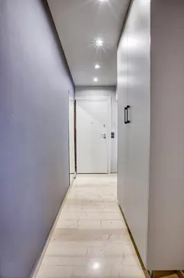 an empty hallway with a white door and a tile floor at Sweet and modern flat at Palaio faliro in Athens