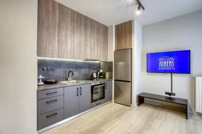 a kitchen with a stainless steel refrigerator and wooden cabinets at Sweet and modern flat at Palaio faliro in Athens