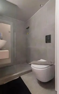 a bathroom with a toilet and a glass shower at Sweet and modern flat at Palaio faliro in Athens